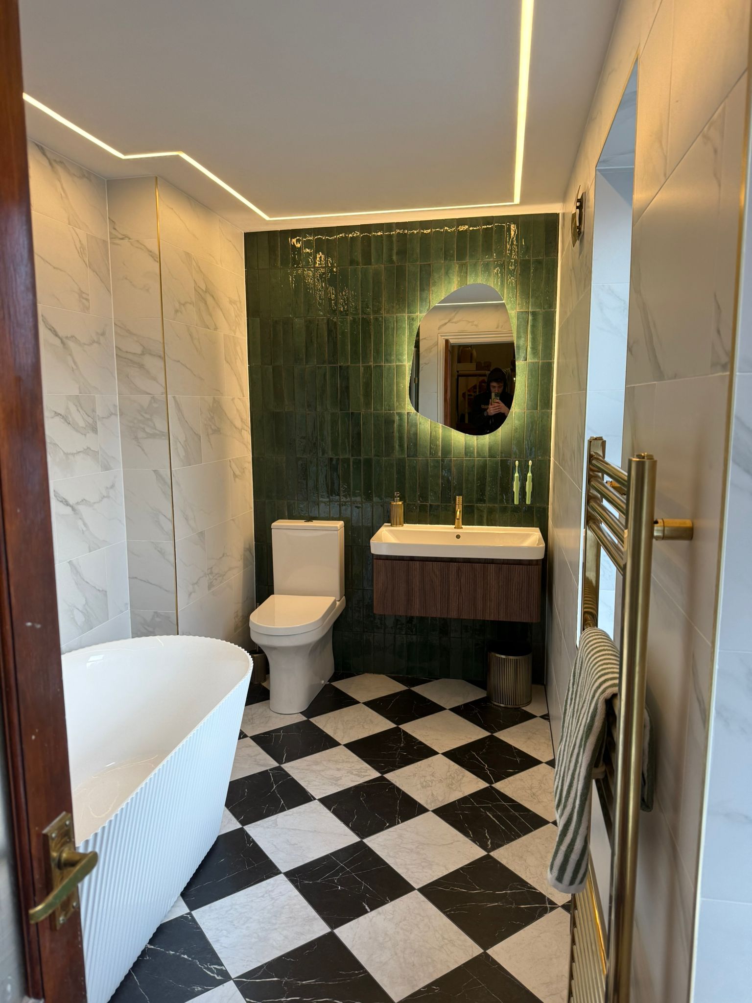 Freestanding fluted bath on chequerboard marble floor