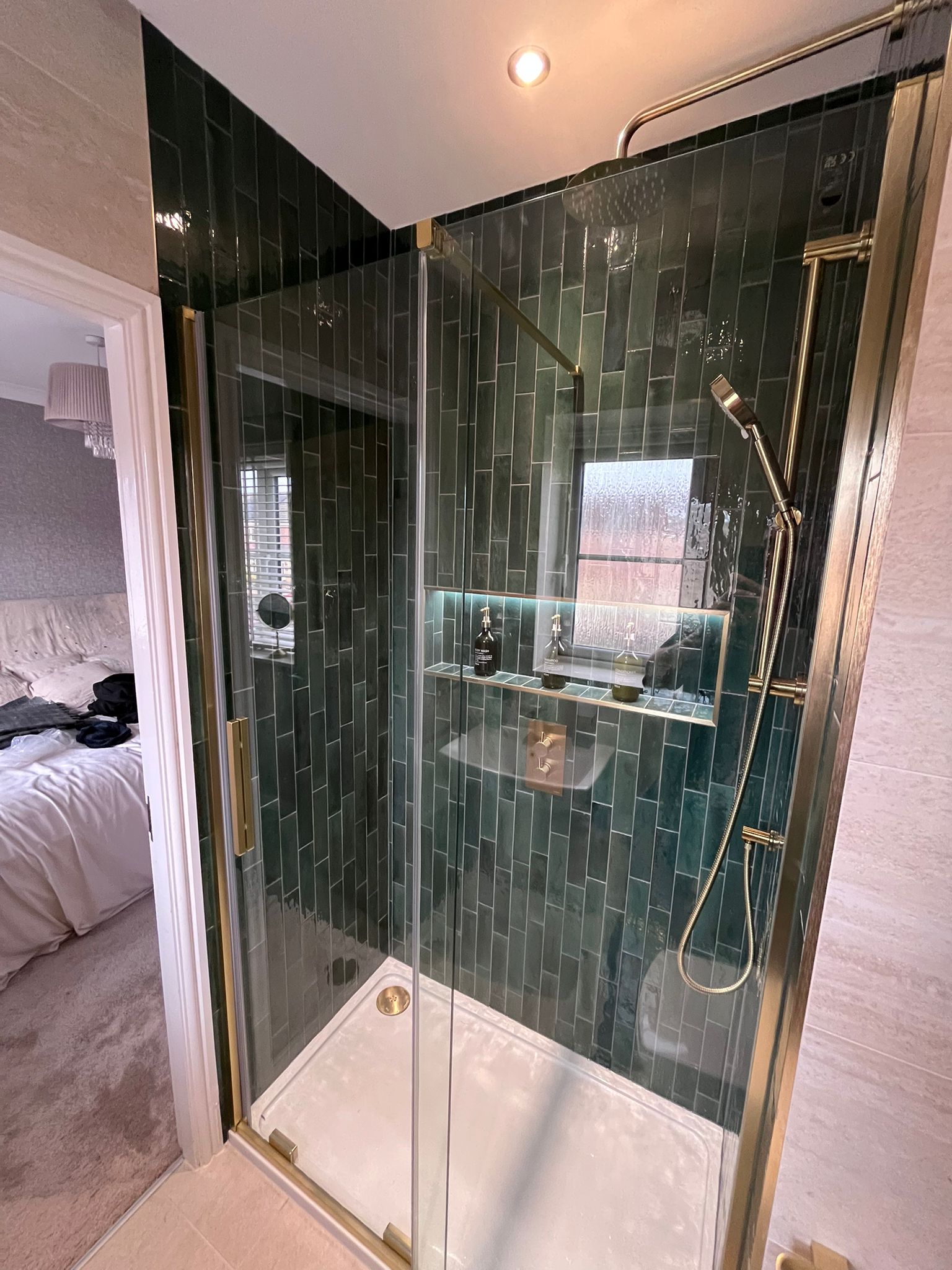 Gold frame shower enclosure with teal tiles