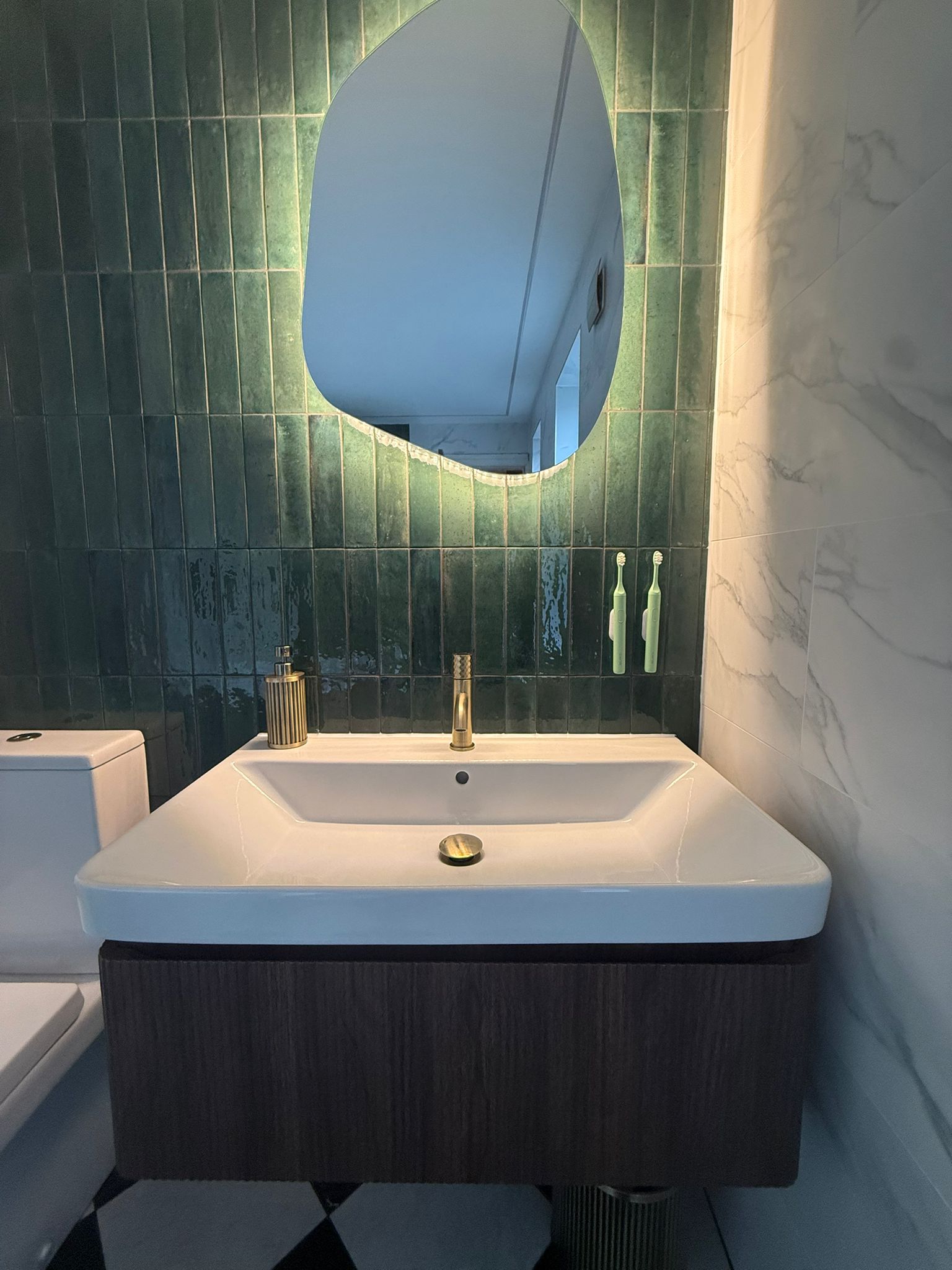 LED backlit mirror with green tile feature wall